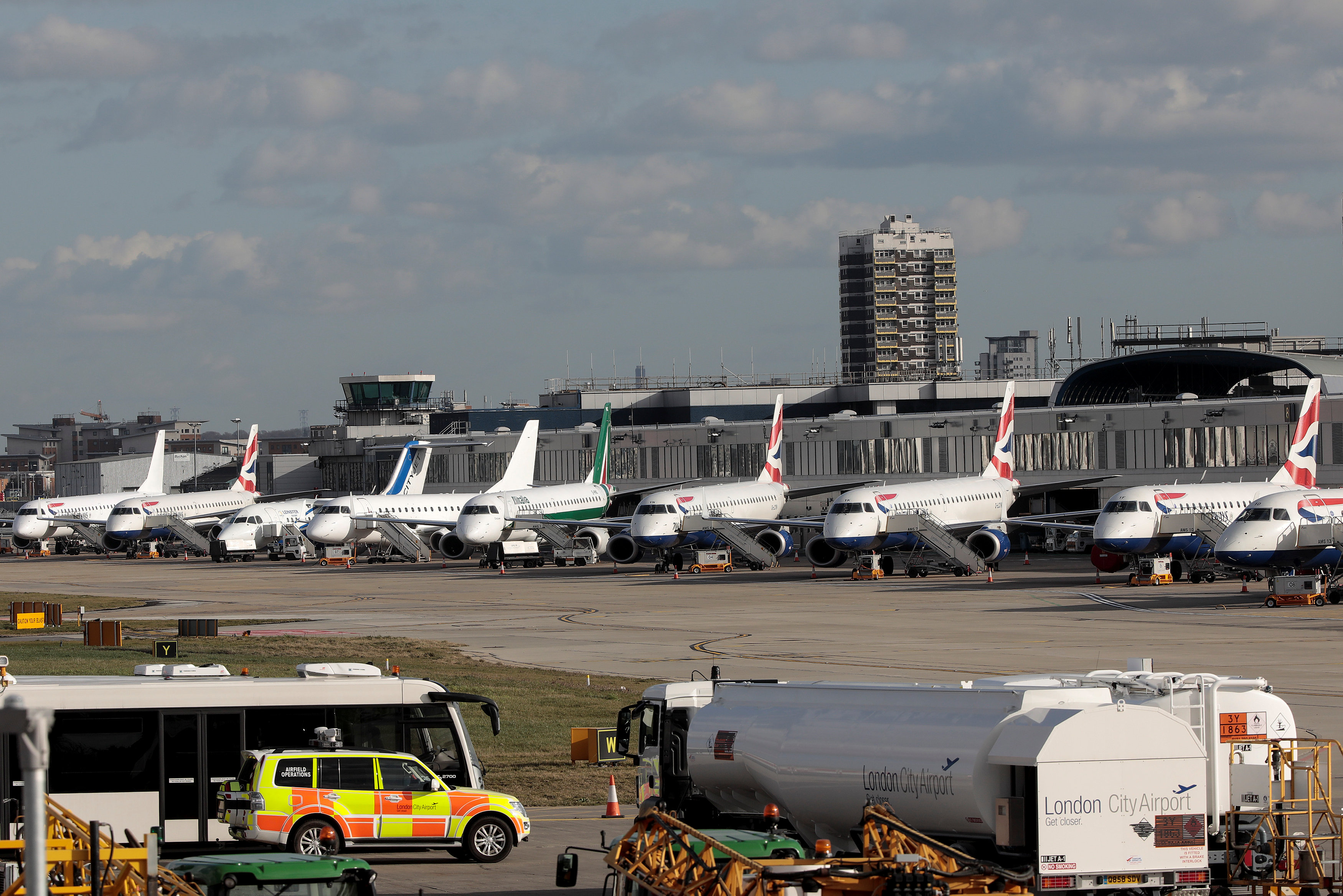 Passenger jets stand on the runway of London City Airport, in London