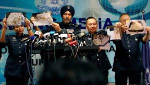 Commissioner Amar Singh, Malaysia’s Federal Commercial Crime Investigation Department (CCID) director, and other police officers display photos of items from a raid during a news conference in Kuala Lumpur