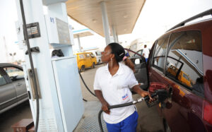 A  fuel attendant fills a tank at a gas